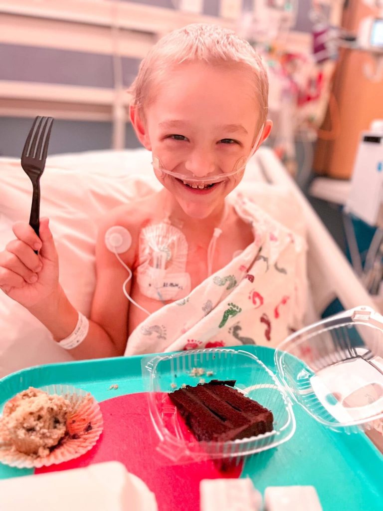 Wilder holding up a fork over a slice of chocolate cake in the hospital